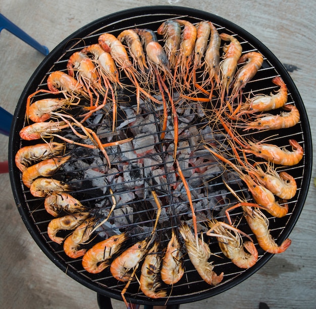 Crevettes grillées sur un cadre en acier avec feu chaud