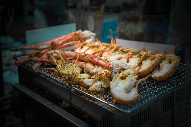 Les crevettes grillées et le crabe sur le gril sont au feu et cuits au marché aux poissons, Japon