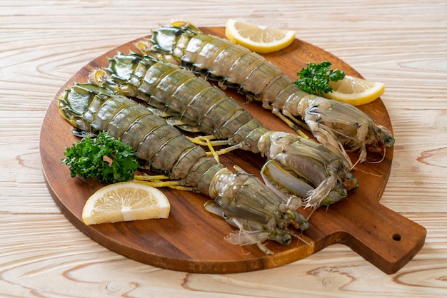 Crevettes mantis fraîches au citron sur planche de bois