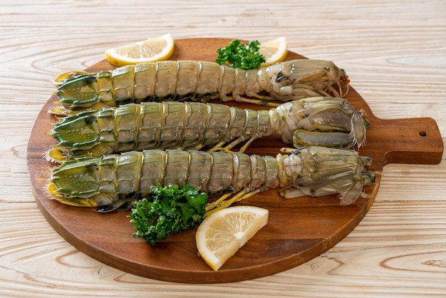 Crevettes mantis fraîches au citron sur planche de bois