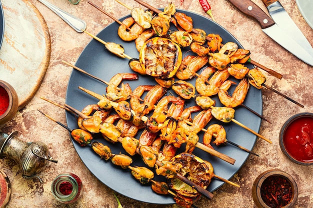 Photo crevettes et moules rôties délicieuses sur des brochettes en bois