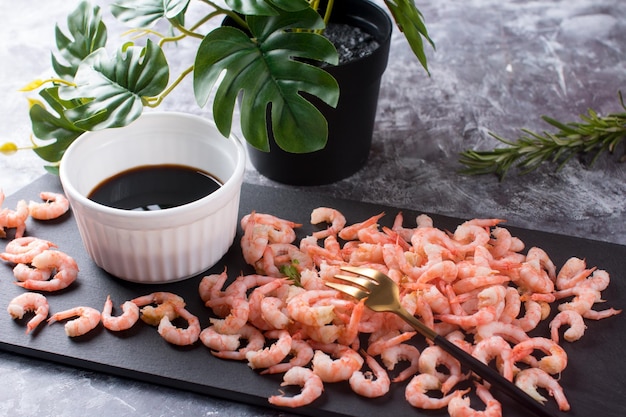 Des crevettes pelées bouillies avec de la sauce soja sur une assiette Des fruits de mer diététiques