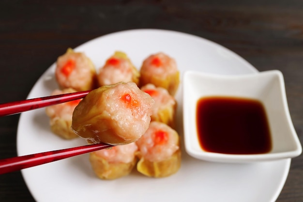 Crevettes et porc rempli de boulettes cuites à la vapeur chinoises cueillies avec des baguettes