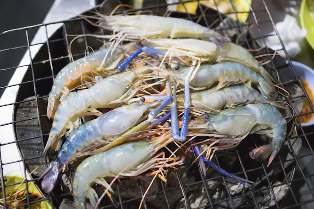 Les crevettes de rivière sont grillées sur des barbecues au charbon de bois.