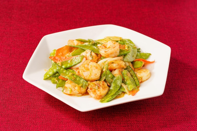 Crevettes sautées aux pois mange-tout sur fond simple