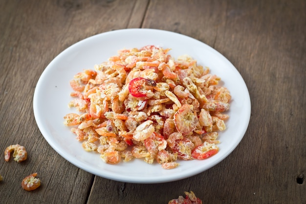 crevettes séchées dans un bol blanc sur la table en bois.