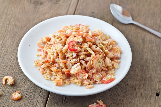 crevettes séchées dans un bol blanc sur la table en bois.