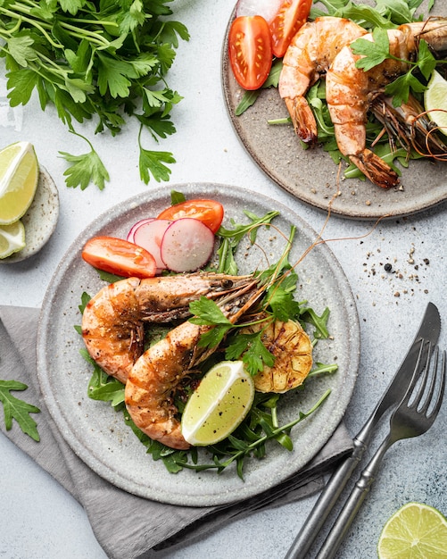 Crevettes tigrées grillées avec des légumes sur une plaque en céramique vue de dessus