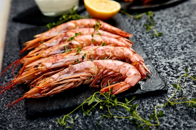 Crevettes tigrées grillées sur une plaque d'ardoise noire