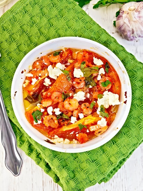 Crevettes et tomates à la feta dans un bol blanc sur le dessus de la serviette