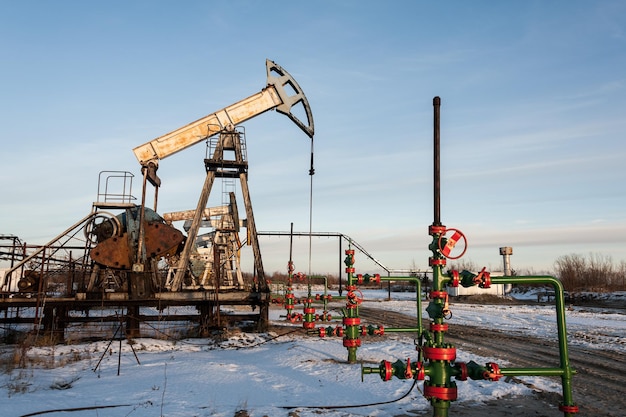 Cric de pompe à huile et tête de puits dans le champ pétrolifère. Notion de pétrole et de gaz.
