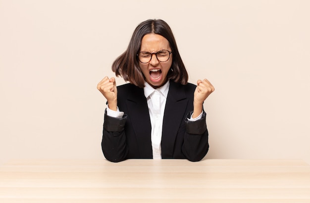 crier agressivement avec une expression de colère ou avec les poings serrés célébrant le succès