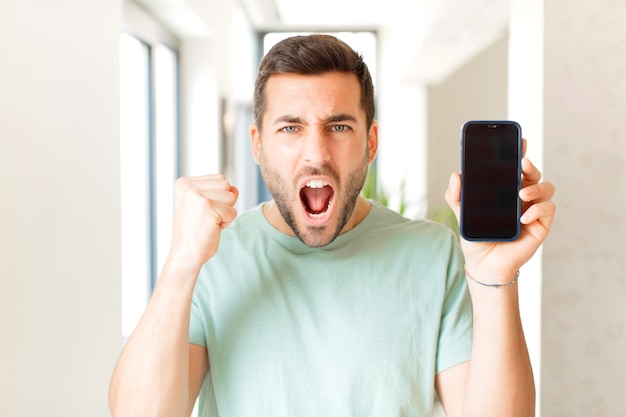 crier agressivement avec une expression de colère ou avec les poings serrés célébrant le succès