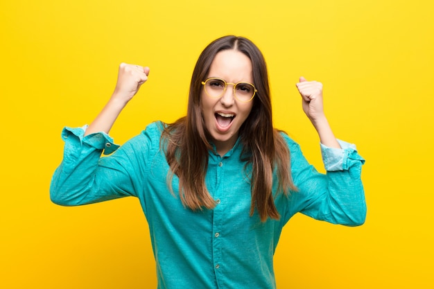 crier agressivement avec une expression de colère ou avec les poings serrés pour célébrer le succès