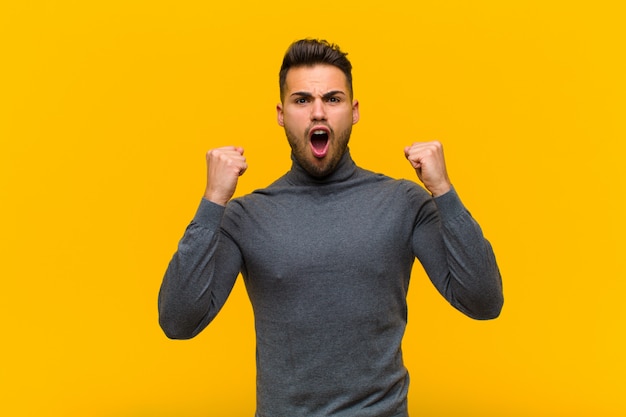 crier agressivement avec une expression de colère ou avec les poings serrés pour célébrer le succès