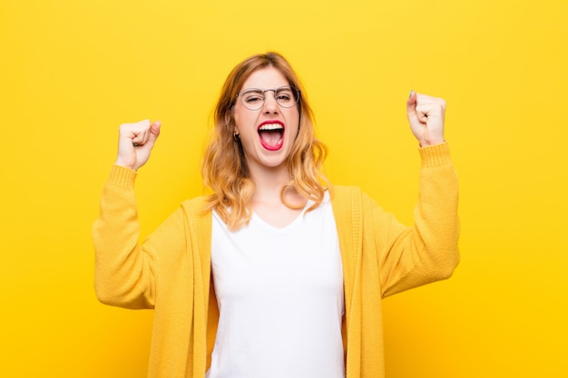 crier agressivement avec une expression de colère ou avec les poings serrés pour célébrer le succès