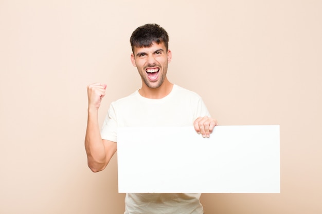 crier agressivement avec une expression de colère ou avec les poings serrés pour célébrer le succès