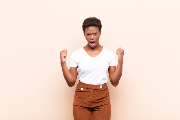 crier agressivement avec une expression de colère ou avec les poings serrés pour célébrer le succès