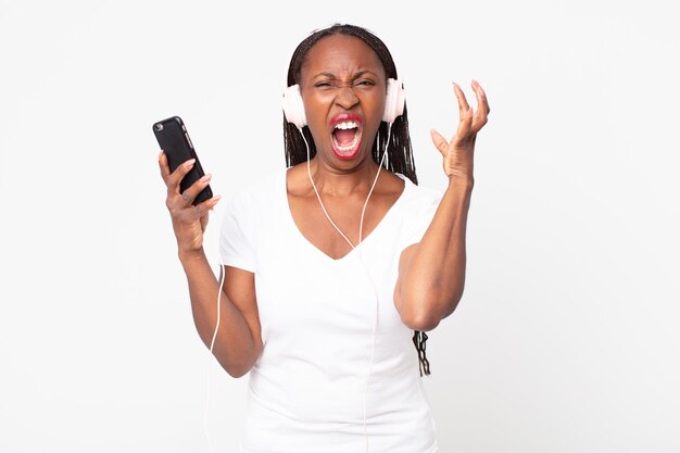 crier avec les mains en l'air avec des écouteurs et un téléphone intelligent