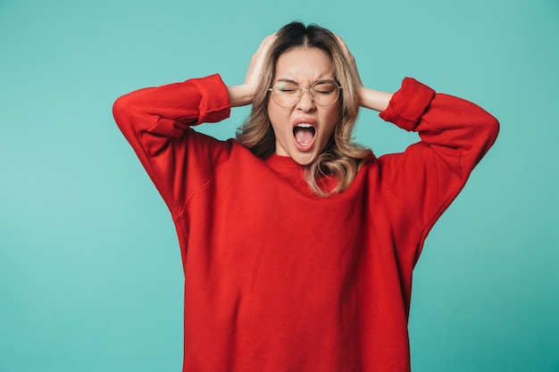 crier, stressé, jeune femme, poser, isolé, sur, mur bleu, mur