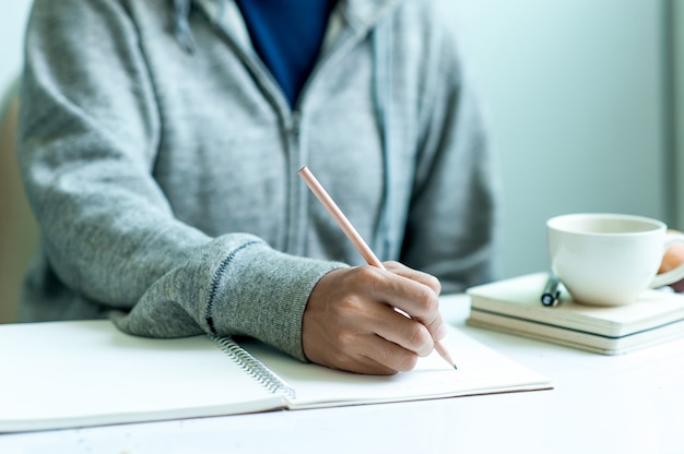 Écrire sur papier au travail sur la table le matin, idées d’affaires. Il y a de la place pour copier.