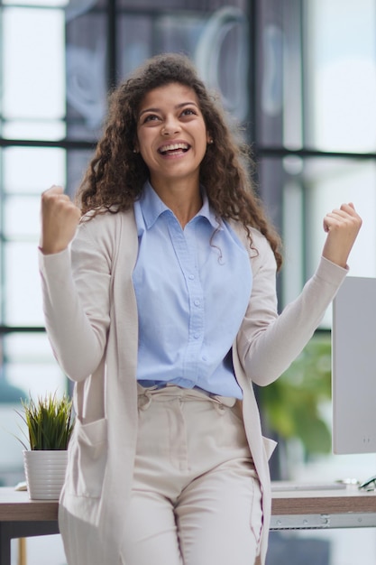 Les cris de femme heureuse font un geste gagnant avec les poings serrés