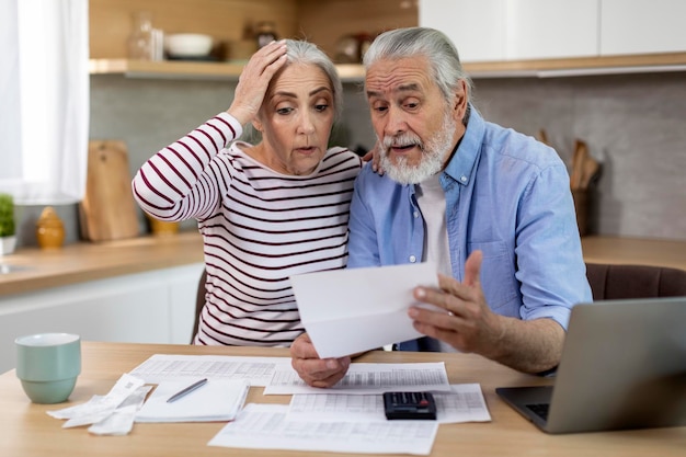 La crise budgétaire a choqué les conjoints âgés vérifiant leurs documents financiers à la maison
