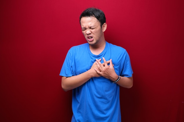 Crise cardiaque ou cœur brisé d'un jeune homme asiatique avec une émotion blessée portant une chemise noire