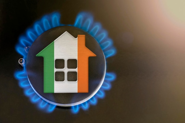 Crise du gaz Hausse des coûts des services publics en Irlande Crise de l'énergie Problèmes d'exportation et d'importation en Irlande Le concept de brûleur à gaz et le modèle de maison sont colorés aux couleurs du drapeau