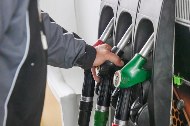 Crise pétrolière Faire le plein d'essence essence Pompe à essence remplissant la buse de carburant dans la station-service Distributeur de carburant Industrie et service de l'essence Buse de carburant essence rouge Industrie pétrolière