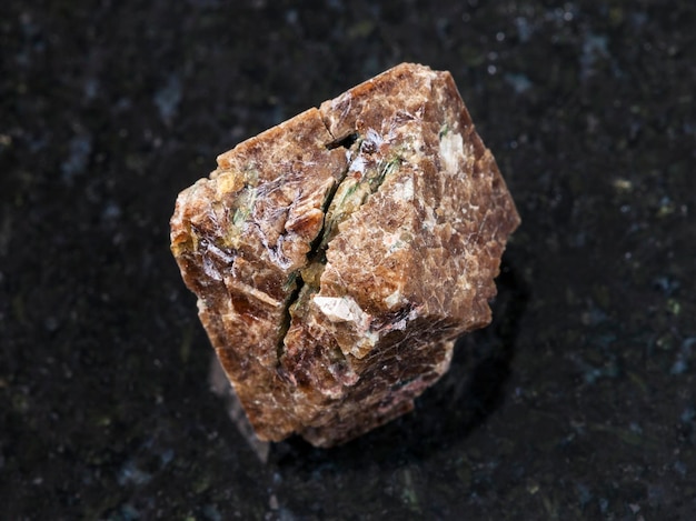 Cristal rugueux de pierre gemme de Zircon sur l'obscurité