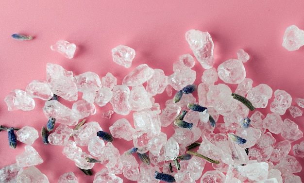 Cristaux de sel de la mer Morte pour le bain, le spa et la détente sur fond rose avec des fleurs de lavande. Protection de l'environnement, respectueux de l'environnement, zéro déchet