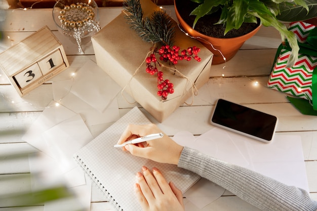 Écrit des souhaits Rêves de plans d'objectifs Faire une liste pour écrire dans un cahier Mains féminines