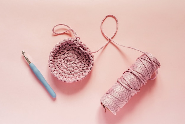 Crochet et fil de couleur rose sur fond rose, fournitures de tricot et de crochet, passe-temps et artisanat