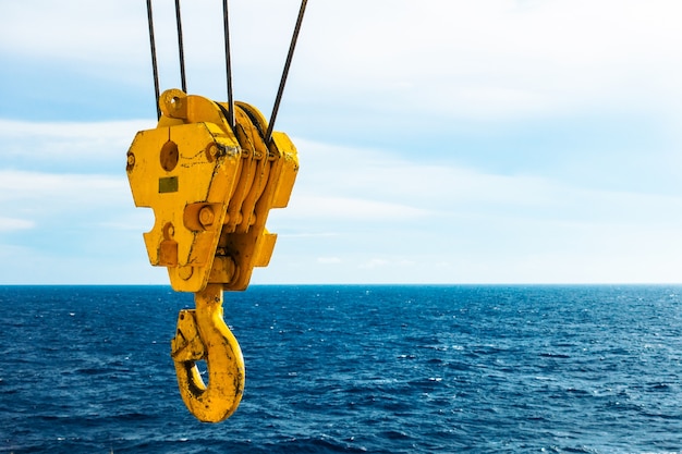 Photo crochet de grue dans la mer avec fond de ciel et de nuages ​​sur la plate-forme offshore