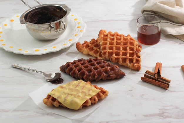 Croffle Croissant Gaufre avec diverses garnitures, fromage, chocolat, sucre et cannelle. Croffle est une cuisine de rue virale de Corée. Mise au point sélectionnée