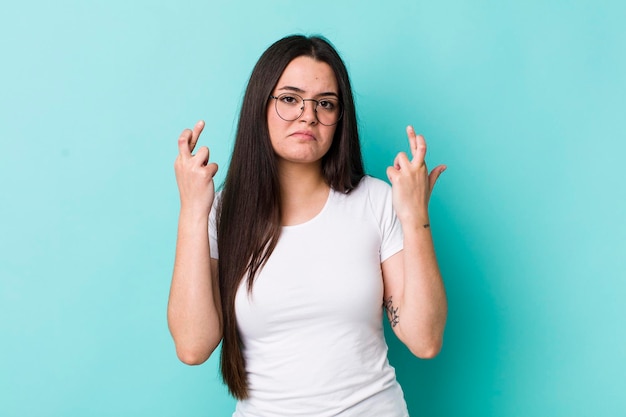 croisant les doigts avec anxiété et espérant bonne chance avec un regard inquiet