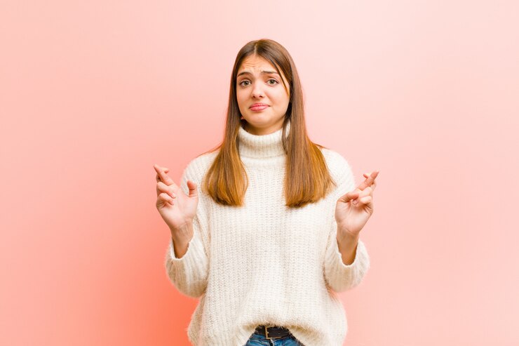 Photo croisant les doigts avec anxiété et espérant bonne chance avec un regard inquiet