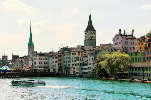 Croiseur fluvial au quai de la Limmat et à l'église Saint-Pierre et à l'église Fraumunster dans le centre-ville de Zurich, en Suisse.