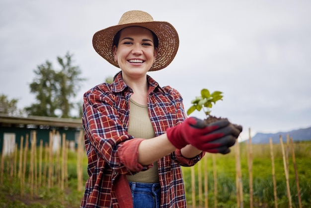 Croissance et durabilité de la ferme avec une agricultrice tenant un sol végétal ou une feuille verte dans l'agriculture et l'industrie agricole Écologie du jardinage et soins écologiques avec une femelle dans un champ