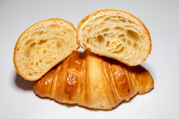 Croissant au beurre brun doré avec ombre isolé sur fond uni