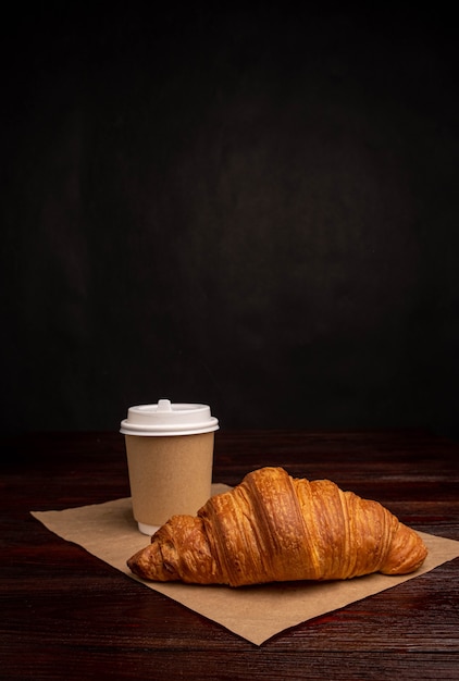 Croissant au café à emporter dans un gobelet en papier, petit-déjeuner à emporter