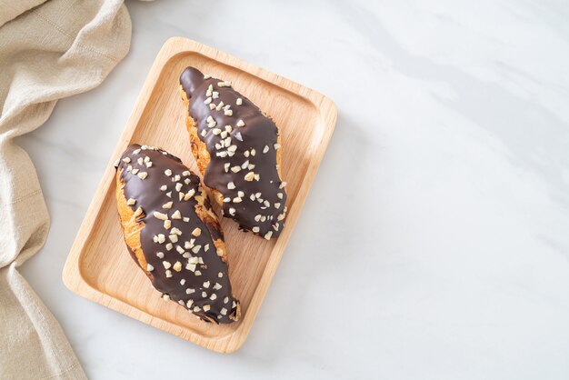 Croissant au chocolat et noisette sur plaque de bois