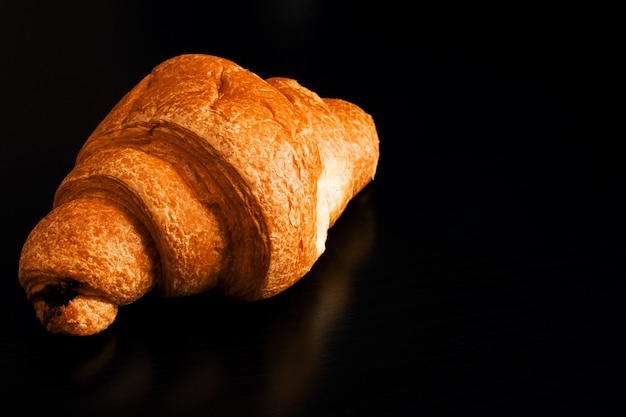 Croissant au chocolat sur table en bois noir