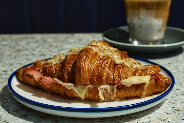 Croissant au fromage jambon gros plan avec fond de café sale