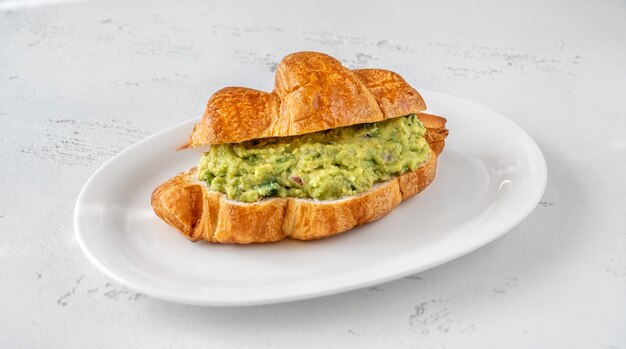 Croissant au guacamole sur l'assiette de service