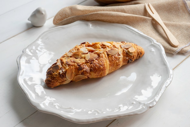 Croissant aux amandes sur plat blanc.