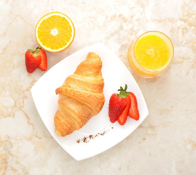 Croissant aux fraises sur une assiette blanche