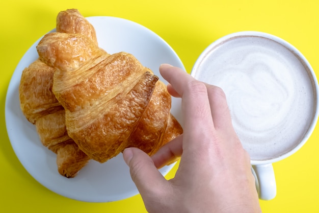 Croissant et cacao chaud ou chocolat chaud sur jaune