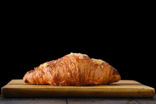 Croissant classique sur planche de service en bois.